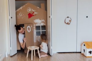 Un père dans une cabane joue avec sa fille